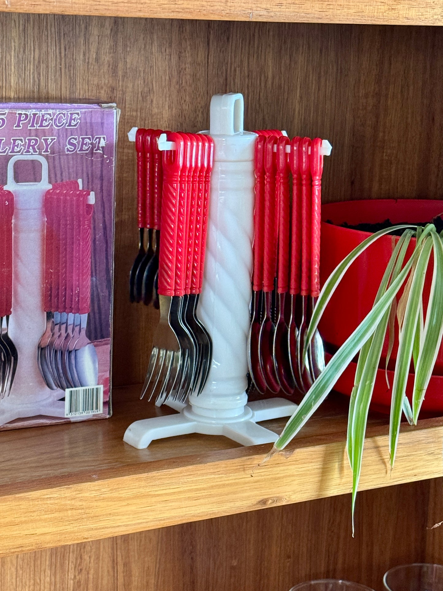 Vintage red twist-handle cutlery set on rotating stand