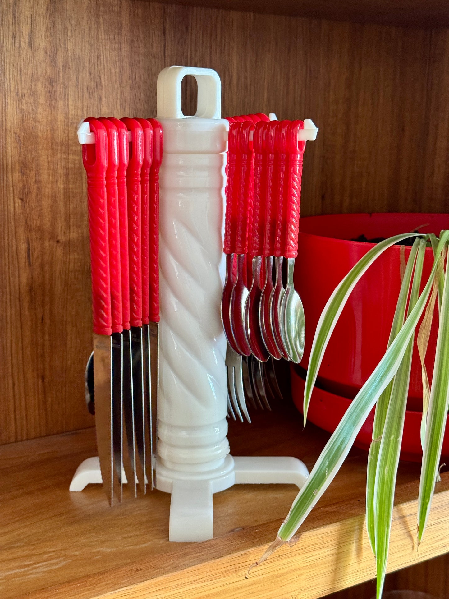 Vintage red twist-handle cutlery set on rotating stand