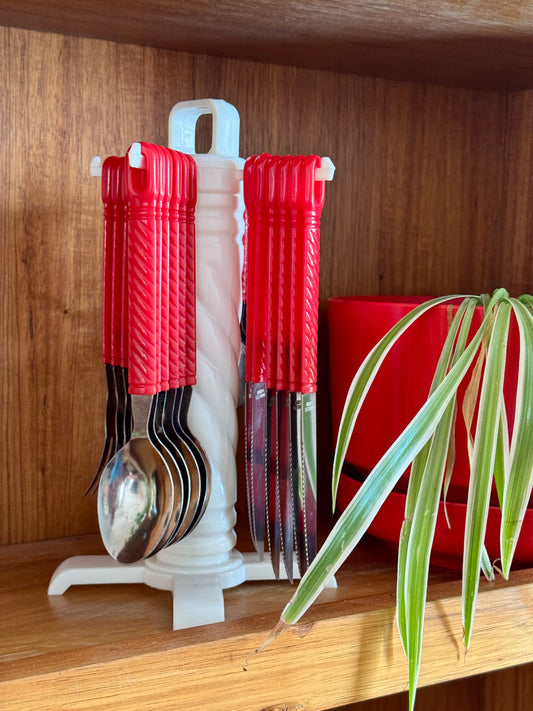 Vintage red twist-handle cutlery set on rotating stand